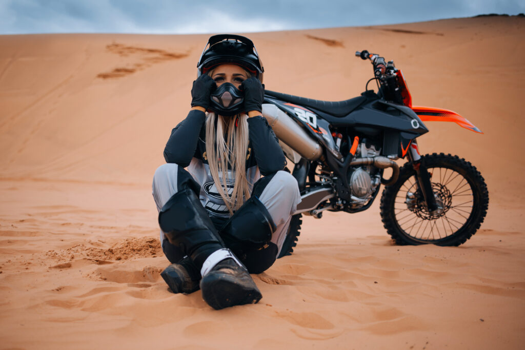Woman,Is,Sitting,At,The,Sands,Near,Enduro,Cross,Dirt